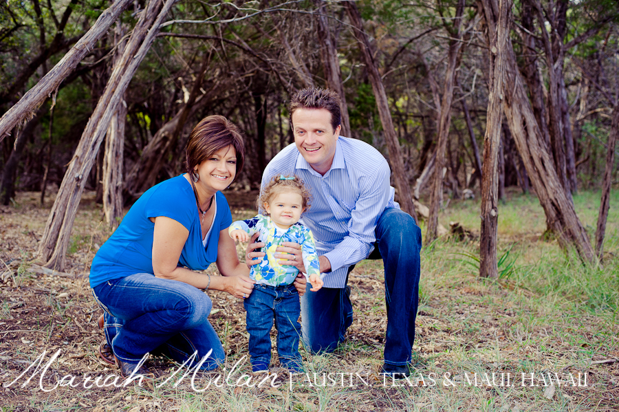family posing in grass and trees