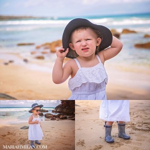 Baby in blue hat and rainboots on the beach