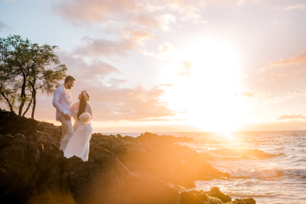 couple eloping on lava rocks at sunset on Maui