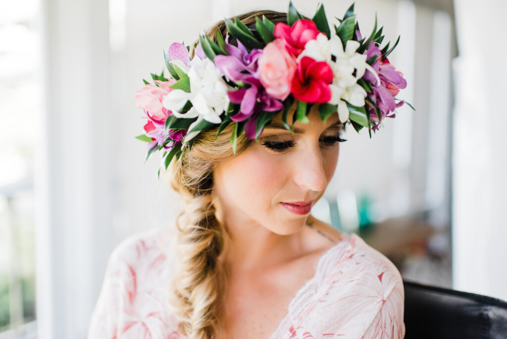 The bride, adorned with a delicate lei, prepares for her elopement, embracing the beauty and tradition of the moment.