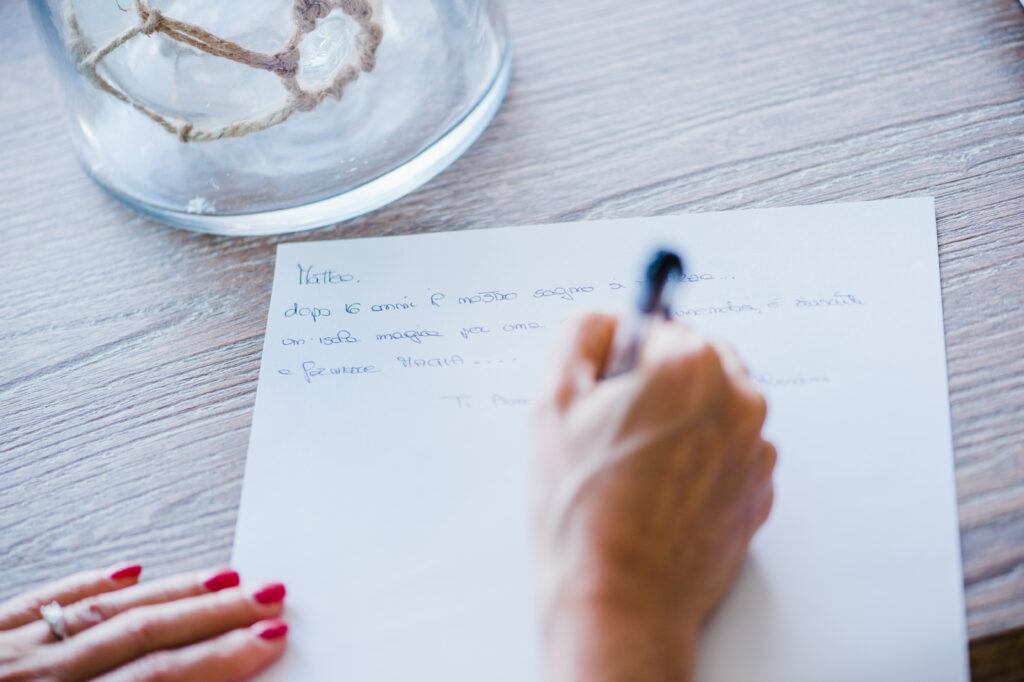 A close-up of the bride’s hand writing her vows on paper on her Maui Elopement.