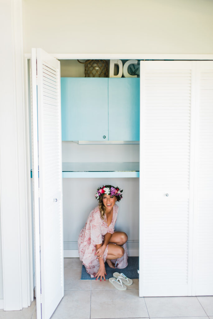 Bride playfully hides in a closet while getting ready for her elopement, sharing a joyful, candid moment.