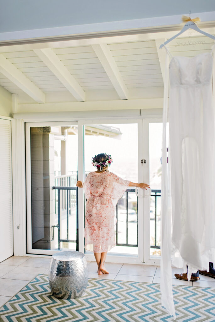 Bride gazing outside the balcony, lost in a quiet moment before the wedding.