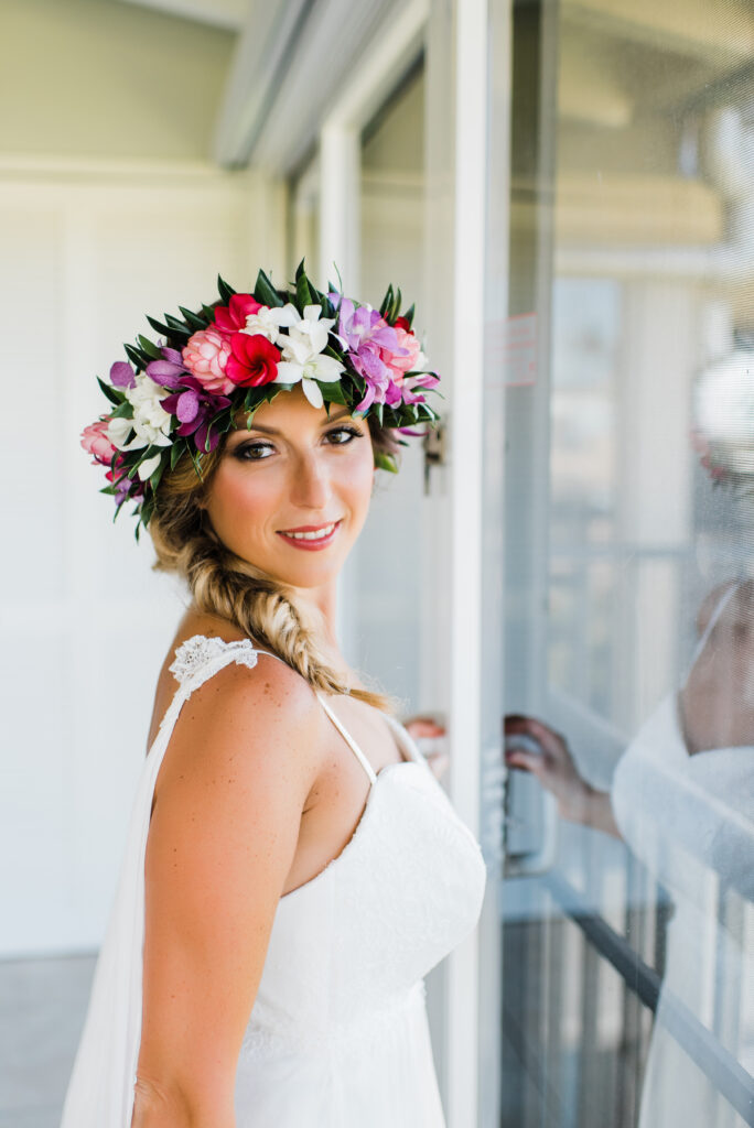 The bride, adorned with a delicate lei, prepares for her elopement, embracing the beauty and tradition of the moment.