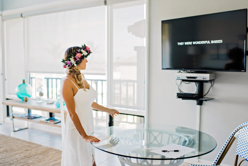 Bride watches a heartfelt video compilation of childhood memories and moments leading to their wedding day.