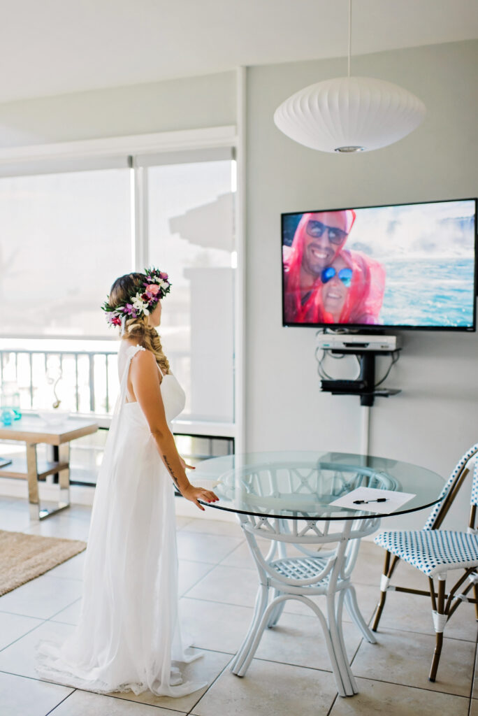 Bride watches a heartfelt video compilation of childhood memories and moments leading to their wedding day.