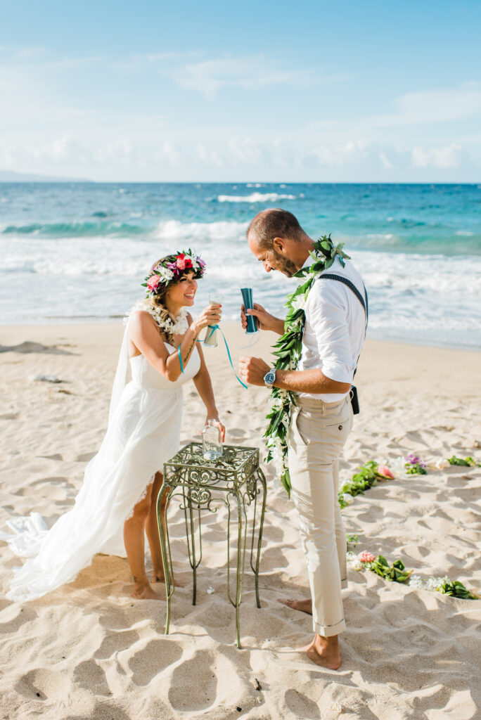 The couple participates in a unique sand ceremony, celebrating the heartfelt moments of their Maui wedding.