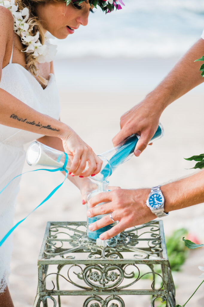 The couple participates in a unique sand ceremony, celebrating the heartfelt moments of their Maui wedding.