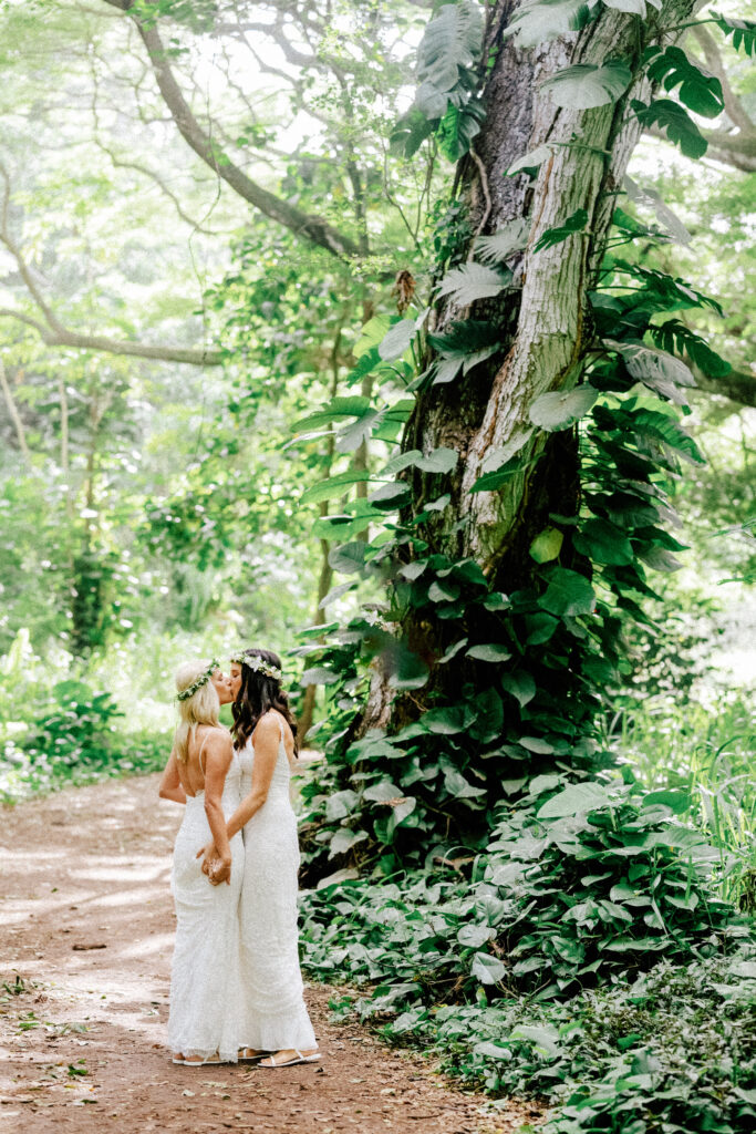 Dori & Natalie share a quiet kiss beneath towering trees in Honolua Forest. Maui elopement bliss.