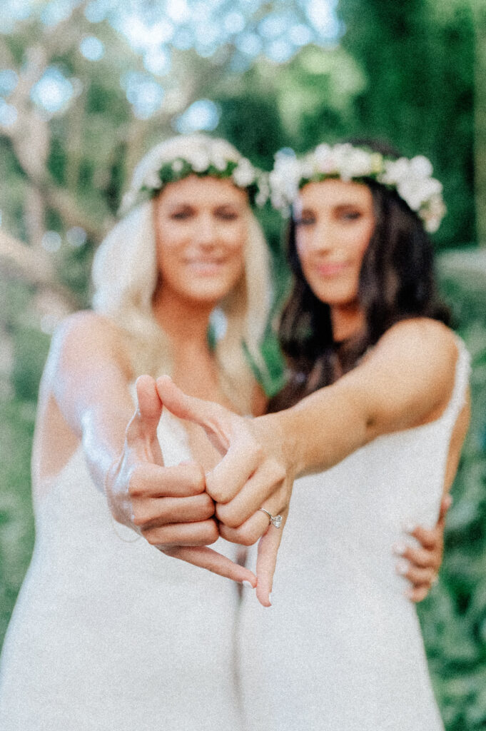 Close-up of the brides proudly showing off their wedding rings, symbolizing their forever love.