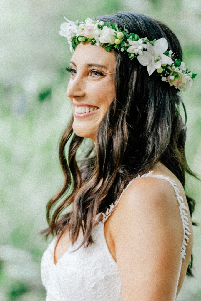Natalie smiles with a floral crown, surrounded by Maui’s tropical greenery.
