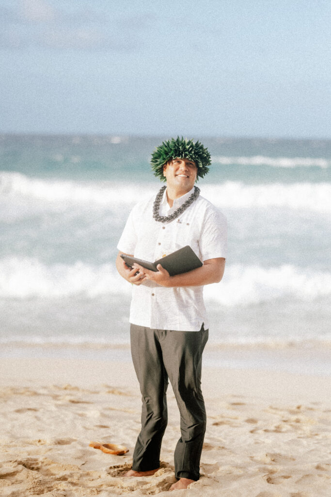 The Hawaiian officiant stands by the ocean, ready to perform the couple’s heartfelt ceremony.
