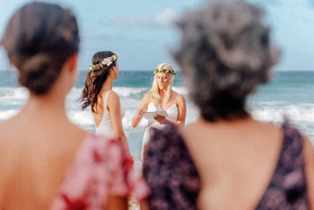 A sentimental moment captured through the eyes of wedding guests on the beach.