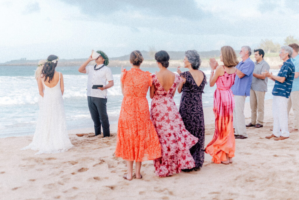 Guests gather on Ironwood Beach, watching the intimate Maui elopement ceremony unfold.