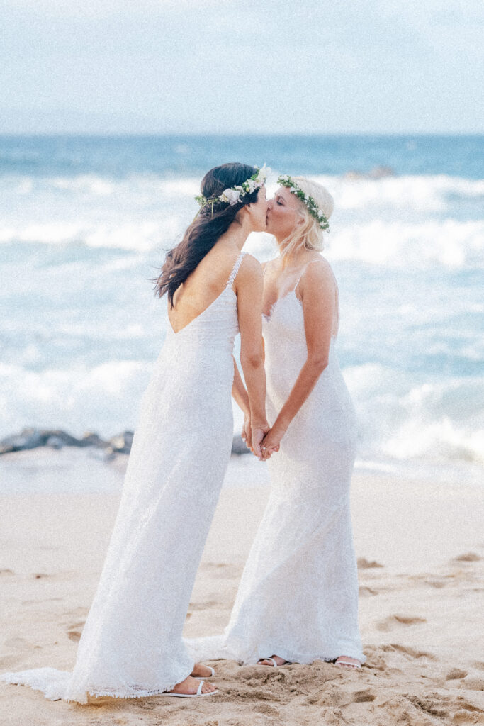A romantic beachside kiss seals Dori & Natalie’s Maui elopement at Ironwood Beach.