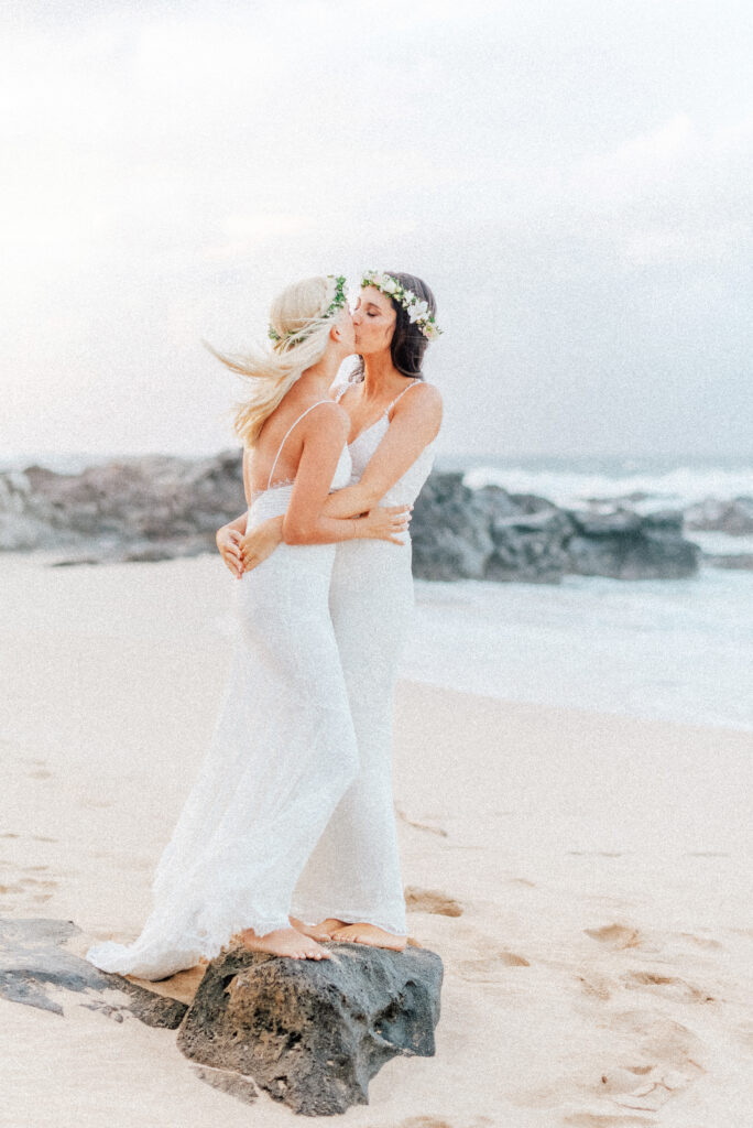 A romantic beachside kiss seals Dori & Natalie’s Maui elopement at Ironwood Beach.