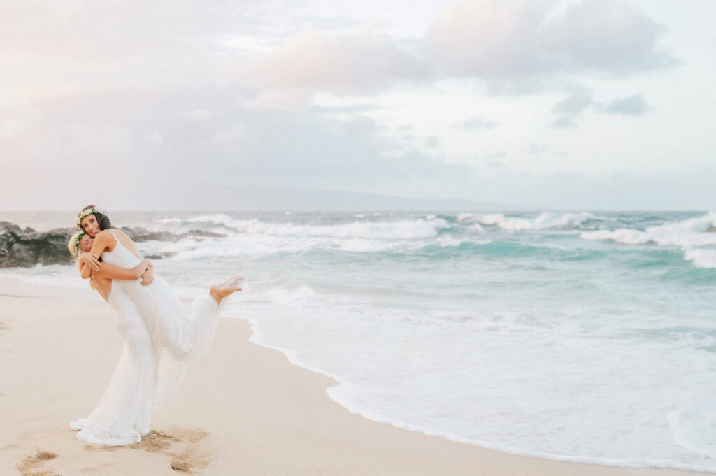 The brides playfully kicks up the sand while dancing along the shore after the ceremony.