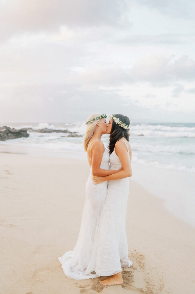A romantic beach kiss, waves crashing around the newlyweds at Ironwood Beach.