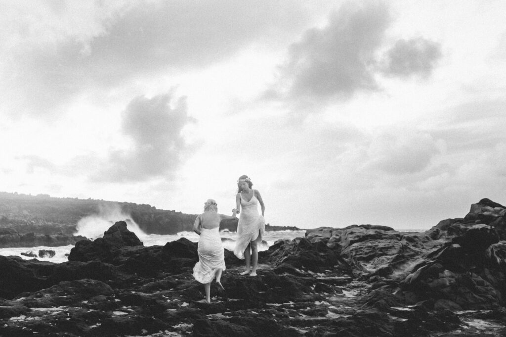 A black-and-white portrait of the couple standing on the cliffs, embracing the ocean breeze.