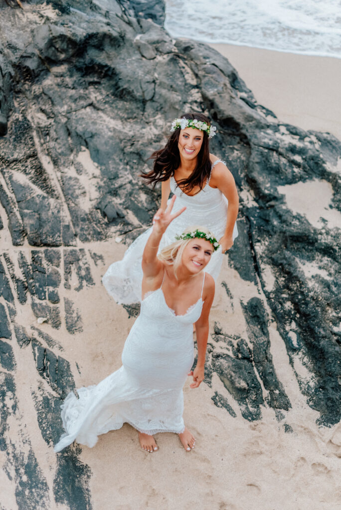 The brides climb Maui’s volcanic rocks, holding hands and embracing adventure.