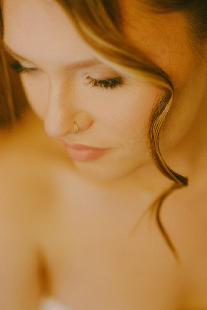 Soft-focus close-up of the bride, highlighting her glowing makeup and romantic hairstyle.
