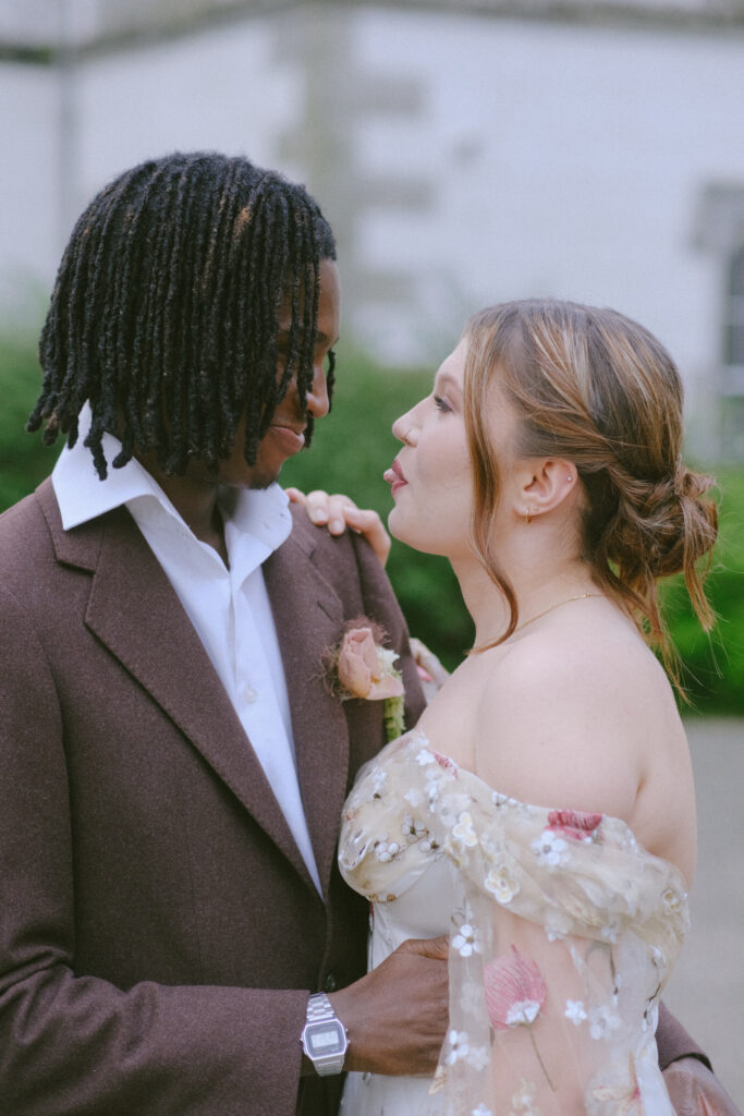 Groom lovingly embraces bride, capturing a candid, tender moment against castle backdrop.